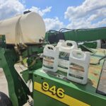 Jugs of ProServe and Wex sitting on a hay mower